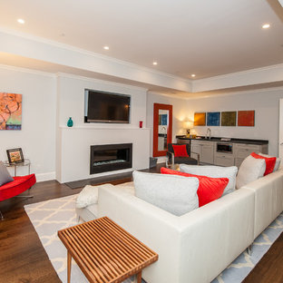 Diseño de sótano en el subsuelo contemporáneo, grande, con paredes azules, suelo de madera oscura y chimenea tradicional