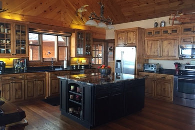 Large elegant u-shaped medium tone wood floor and brown floor open concept kitchen photo in Other with an undermount sink, raised-panel cabinets, medium tone wood cabinets, granite countertops, stainless steel appliances and an island