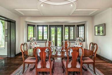 Inspiration for a mid-sized craftsman dark wood floor and brown floor enclosed dining room remodel in Kansas City with white walls and no fireplace