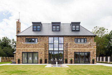 Expansive transitional three-storey brick house exterior in Hertfordshire with a hip roof and a shingle roof.