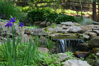 Photo of a mid-sized victorian partial sun hillside stone landscaping in Other.