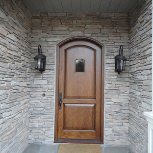Modelo de puerta principal ecléctica con paredes grises, suelo de pizarra, puerta simple y puerta de madera en tonos medios