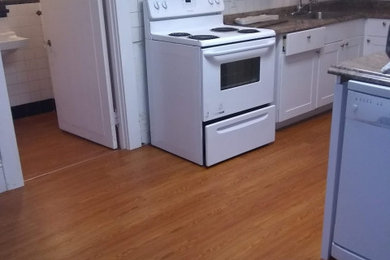 Elegant light wood floor and brown floor kitchen photo in Boston