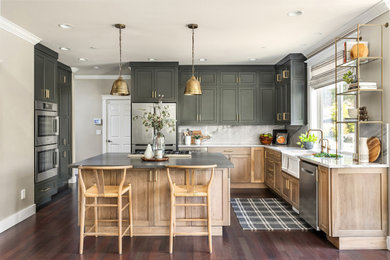 Mid-sized transitional l-shaped dark wood floor and brown floor kitchen pantry photo in Seattle with a farmhouse sink, shaker cabinets, green cabinets, quartzite countertops, white backsplash, stone slab backsplash, stainless steel appliances, an island and white countertops