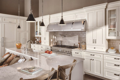 Mid-sized transitional u-shaped dark wood floor and brown floor open concept kitchen photo in San Diego with a farmhouse sink, shaker cabinets, white cabinets, marble countertops, beige backsplash, subway tile backsplash, stainless steel appliances and an island