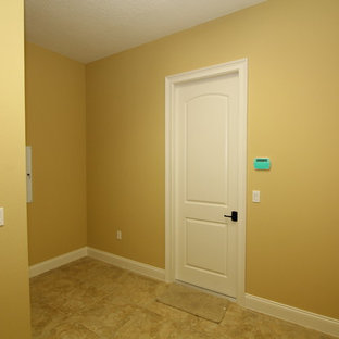 Idéer för en stor klassisk hall, med gula väggar och klinkergolv i porslin