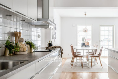 Inspiration for a scandinavian galley eat-in kitchen in Other with flat-panel cabinets, white cabinets, white splashback, porcelain splashback, laminate floors, grey benchtop, an undermount sink, no island and beige floor.
