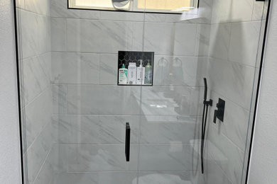 Inspiration for a mid-sized contemporary kids' white tile and porcelain tile porcelain tile, black floor and wall paneling alcove shower remodel in San Diego with a two-piece toilet, white walls, an undermount sink, a hinged shower door, white countertops, a niche and a built-in vanity