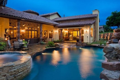Inspiration for a mid-sized modern backyard stamped concrete and custom-shaped natural pool remodel in Los Angeles