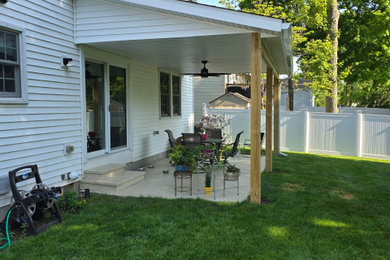 Mid-sized elegant backyard patio photo in Cleveland with a roof extension