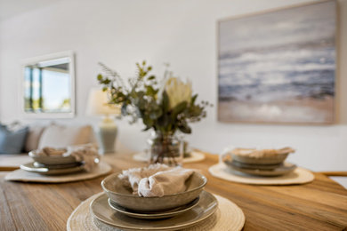 Mid-sized transitional open plan dining in Sunshine Coast with white walls, ceramic floors and white floor.