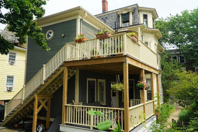 Example of a backyard wood railing deck design in Boston