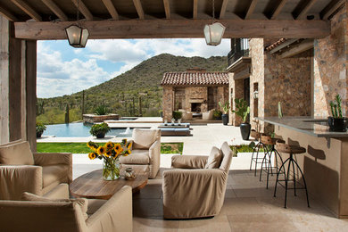 Inspiration for a large southwestern backyard tile patio kitchen remodel in Phoenix with a pergola