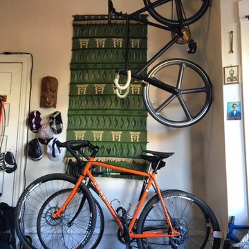 Track bike on the wall, perched above a trail and road bike.