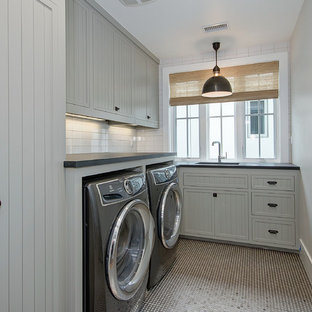 Photo of a medium sized rural l-shaped separated utility room in Orange County with a submerged sink, recessed-panel cabinets, grey cabinets, soapstone worktops, grey walls, a side by side washer and dryer and black worktops.