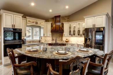 Example of a large classic l-shaped porcelain tile and beige floor open concept kitchen design in Other with raised-panel cabinets, white cabinets, quartz countertops, beige backsplash, marble backsplash, stainless steel appliances and an island