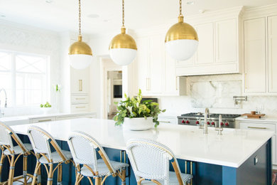 Example of a transitional l-shaped kitchen design in Jacksonville with a farmhouse sink, shaker cabinets, white cabinets, white backsplash, stainless steel appliances, an island and white countertops