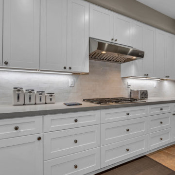 Sleek White Cabinetry and Subtle Backsplash in Modern Laguna Niguel Kitchen