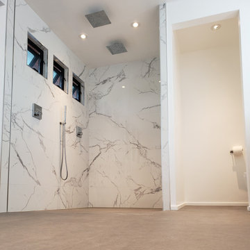 Custom Bathroom with heated floors, integrated glass channels, and a curbless wa