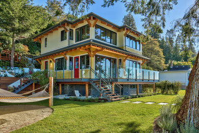 Inspiration for a coastal yellow three-story mixed siding house exterior remodel in Vancouver with a hip roof