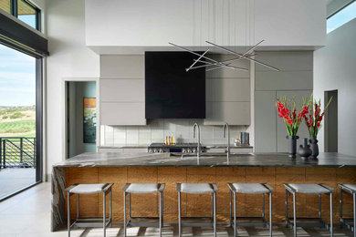 Inspiration for a huge contemporary galley gray floor kitchen remodel in Denver with an undermount sink, flat-panel cabinets, gray cabinets, gray backsplash, glass tile backsplash, stainless steel appliances, an island and black countertops