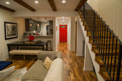 Inspiration for a mid-sized transitional open concept medium tone wood floor living room remodel in Los Angeles with a bar, white walls and a wall-mounted tv