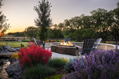 Inspiration for a large contemporary backyard stone patio remodel in Denver with a fire pit