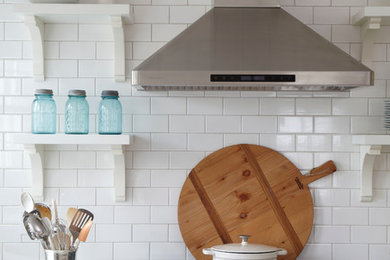 Inspiration for a farmhouse u-shaped eat-in kitchen remodel in Atlanta with a farmhouse sink, shaker cabinets, white cabinets, granite countertops, white backsplash, ceramic backsplash and stainless steel appliances