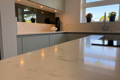 Medium sized contemporary l-shaped enclosed kitchen in Hampshire with an island.