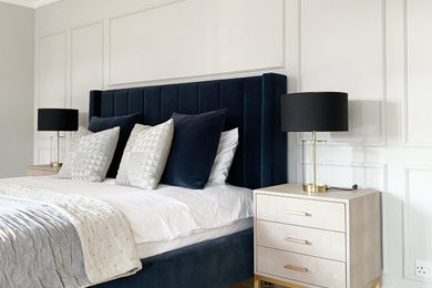 サリーにある北欧スタイルのおしゃれな主寝室 (グレーの壁、淡色無垢フローリング、茶色い床、パネル壁)