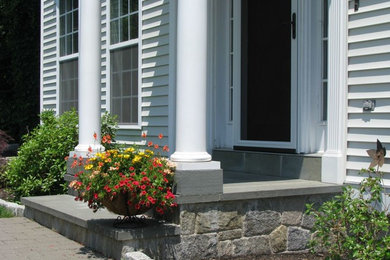 This is an example of a large traditional full sun backyard stone retaining wall landscape in New York.