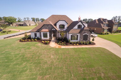 Inspiration for a large rustic white two-story brick house exterior remodel with a hip roof and a shingle roof