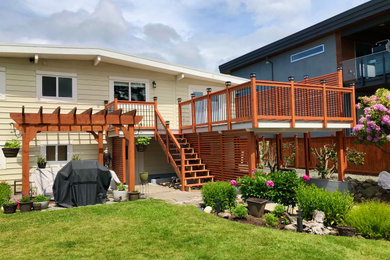 Arts and crafts backyard privacy deck photo in Vancouver
