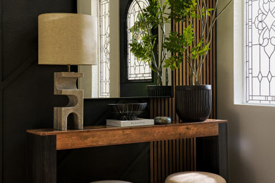 Entryway - large transitional vinyl floor, brown floor and wall paneling entryway idea in Los Angeles with black walls