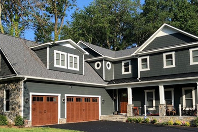 Example of a large arts and crafts blue two-story mixed siding house exterior design in DC Metro with a hip roof and a mixed material roof