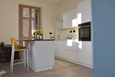 Foto di una piccola cucina minimalista con ante lisce, ante bianche, top in laminato, top bianco e paraspruzzi bianco