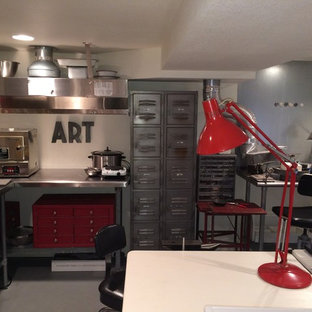 Inspiration for an expansive industrial home studio in Portland with white walls, concrete floors, no fireplace and a freestanding desk.