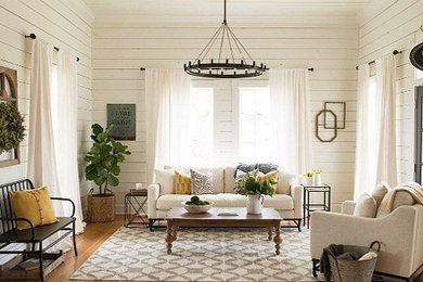 Example of a mid-sized country medium tone wood floor and brown floor living room design in San Luis Obispo with white walls