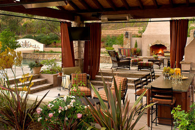 Inspiration for a large mediterranean backyard patio in Los Angeles with an outdoor kitchen, natural stone pavers and a gazebo/cabana.