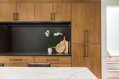 Foto di una grande cucina con ante in legno scuro, top in quarzite, paraspruzzi a effetto metallico, parquet chiaro e top bianco