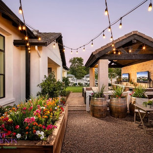 This is an example of a large modern backyard partial sun formal garden for summer in Phoenix with with fireplace and brick pavers.
