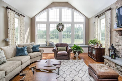 Family room - large transitional open concept light wood floor family room idea in Philadelphia with beige walls, a standard fireplace, a stone fireplace and a wall-mounted tv
