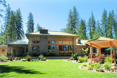 Photo of a mid-sized arts and crafts two-storey grey house exterior in Sacramento with wood siding, a hip roof and a metal roof.