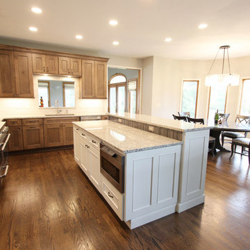 Two Toned Kitchen with White Island and Great Room Stacked Stone Fireplace