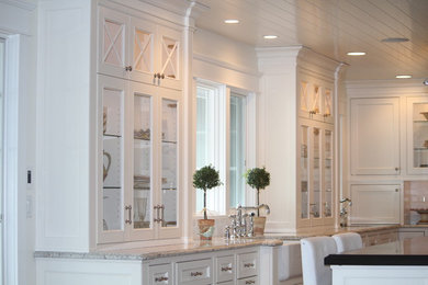 Example of a mid-sized beach style u-shaped open concept kitchen design in Grand Rapids with a farmhouse sink, recessed-panel cabinets, white cabinets, granite countertops, white backsplash, subway tile backsplash, stainless steel appliances and an island