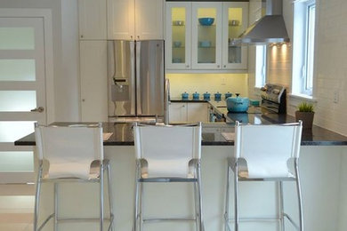 Kitchen - mid-sized traditional l-shaped porcelain tile kitchen idea in Ottawa with a single-bowl sink, shaker cabinets, white cabinets, granite countertops, white backsplash, ceramic backsplash and stainless steel appliances