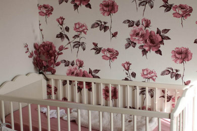 Réalisation d'une petite chambre de bébé fille avec un mur beige, sol en stratifié, un sol beige et du papier peint.