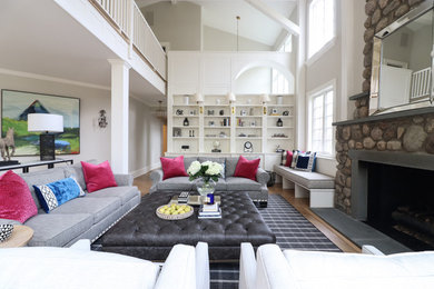 Transitional formal and open concept medium tone wood floor and brown floor living room photo in New York with white walls, a standard fireplace, a stone fireplace and no tv