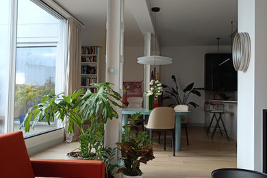 Modelo de salón con barra de bar abierto y beige y blanco contemporáneo grande con paredes blancas, suelo de madera en tonos medios, chimenea de doble cara, marco de chimenea de metal, televisor colgado en la pared, suelo beige, bandeja, piedra y alfombra