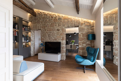 Immagine di un piccolo soggiorno minimal stile loft con libreria, parquet scuro, travi a vista e pareti in mattoni